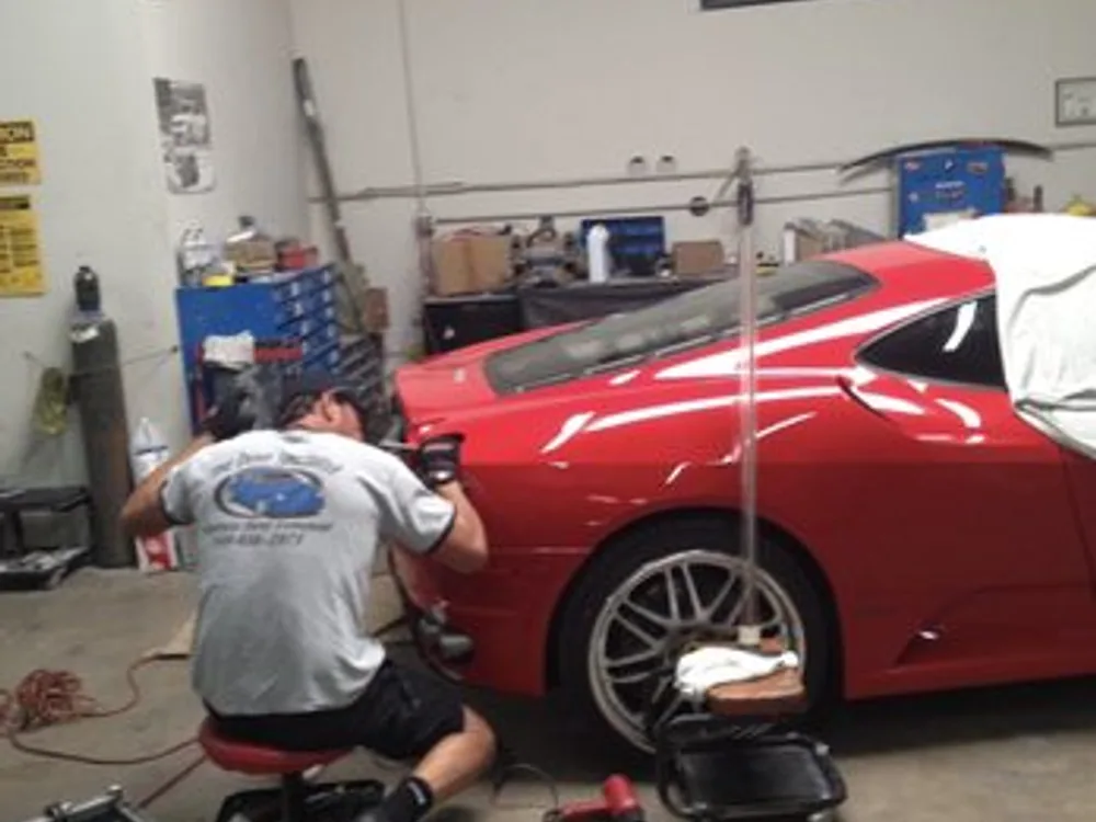 Dave, The Dent Specialist, performing paintless dent repair on a car in his shop