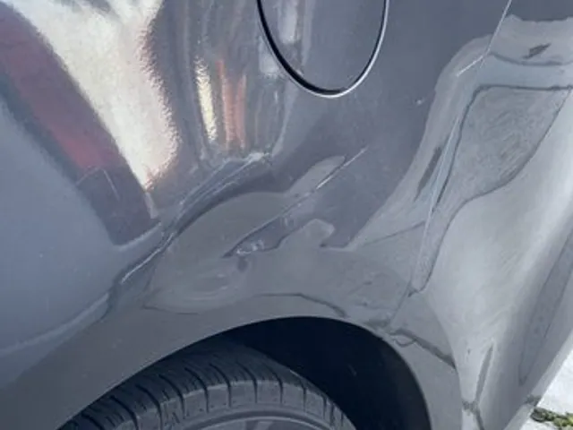 Deep crease on a silver SUV quarter panel before paintless dent repair