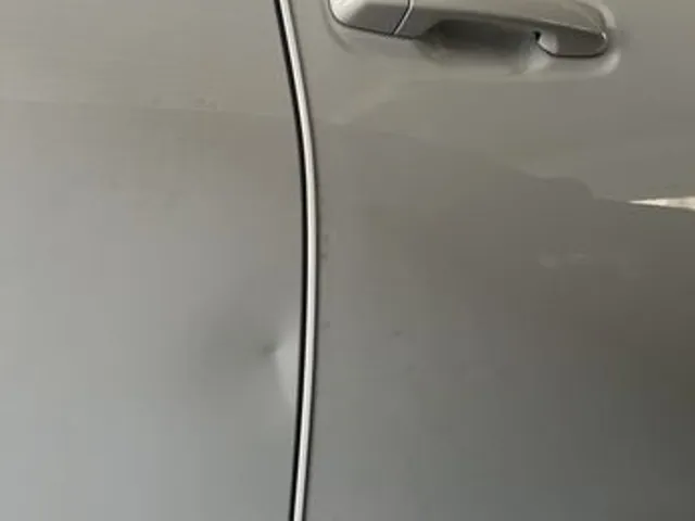 Gold car door after paintless dent repair