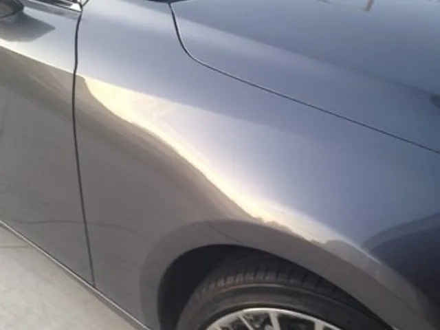 Gray sedan side panel after dent repair