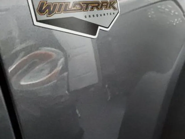 Dent near the badge on a Ford Bronco before repair