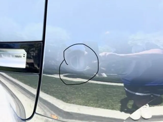 Door dent circled in marker before paintless dent repair